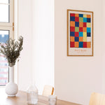 Farverig Paul Klee plakat i egetræsramme på væg i stue